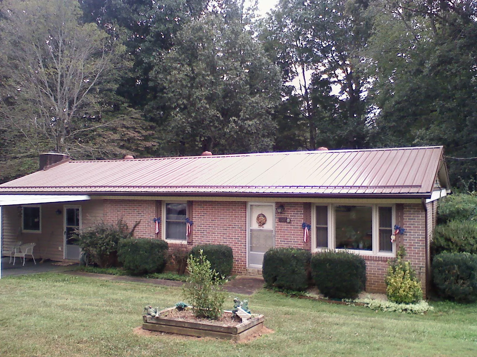 Bronze metal roof on a brick ranch home with a carport in Gallatin