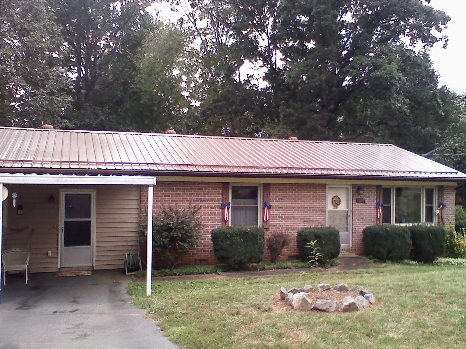 Bronze metal roof and carport on a brick ranch home — Roof Repair work by our crew in Gallatin