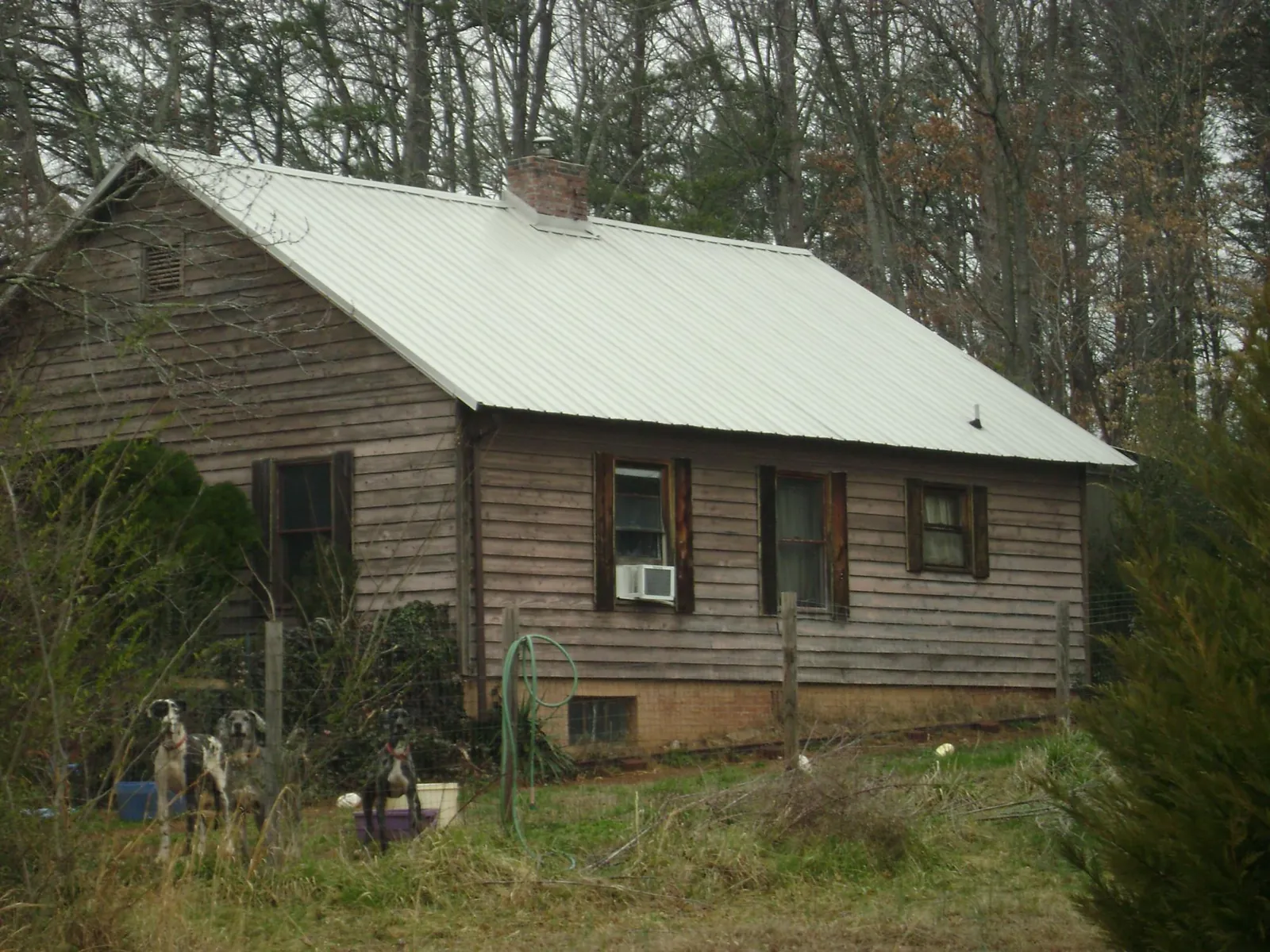 White metal roof on an old wood sided farmhouse, from a Metal Roof Installation job in Gallatin